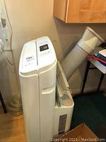 Side angle view of full portable air conditioner unit with vent hose attached.