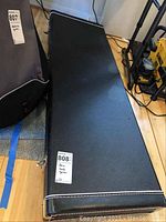 Closed black hard shell rectangular case with white stitching and metal corner protectors