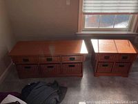 Two wooden storage cubbies side by side under a window, showing overall sizes and design.