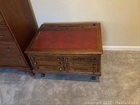 Full front view of oak spool cabinet with red inset top and six drawers