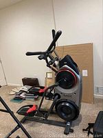 Front perspective view showing overall unit with foot pedals, flywheel housing, handlebars