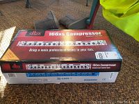 Red DBX 166xs Compressor box showing front panel graphics and model name