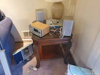 Wood finish Sharper Image SO226 radio, Sangean CD player/radio with speakers on wooden side table.