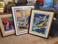Three framed Neiman prints leaning against sofa
