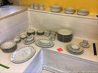 Full view of the complete Johann Haviland Bavaria Germany dinnerware set arranged on white steps, shows all plates, bowls, cups, saucers, and serving dishes with floral pattern and gold trim.