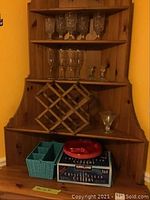 Photos showing vintage pressed glassware on wooden shelves including goblets and champagne flutes, two glass candle holders, a wooden foldable wine rack, and picnic basket with plates and cutlery in box.