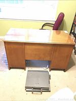 Front view of the wood desk showing the glass top, solid sides, and overall shape.