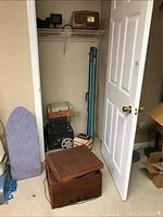 Photo showing closet with vintage electronics including record players, reel to reel player, projector screen, and vintage cameras visible.