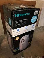 Boxed Hisense portable air conditioner displayed upright on floor.