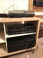 Stereo setup showing turntable on top shelf and Optimus receiver on bottom shelf with wires visible.