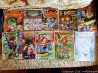 Photo showing all 10 DC Comics comic books featuring various series and characters, arranged in two rows on a fabric surface.