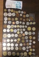 Wide view showing layout of various coins and a few currency notes including English note.