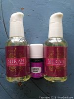 Three Young Living products displayed: two Mirah Shave Oil bottles (59ml each) with white pump tops and one small Lavender Essential Oil bottle (5ml) with white cap.