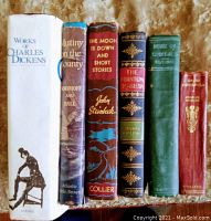 Photo showing the spines of six hardcover classic literature books including Works of Charles Dickens, Mutiny on the Bounty, The Moon is Down and Short Stories, The Phantom Rickshaw, House of Seven Gables, and David Copperfield.