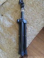 Folded Profile professional grade adjustable speaker stand showing its compact foldable tripod design with knobs.