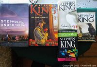 Photo shows the six Stephen King books laid out, including Under the Dome, The Dark Tower VII, Salem's Lot, The Green Mile boxed set, The Dark Tower I, and The Gunslinger.