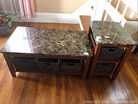 Coffee table and side table set, both with marble-like veneer tops and woven baskets underneath for storage, photographed on hardwood floor near stairs.