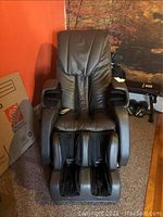 Front view of brown massage chair with footrest compartments