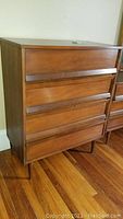 Front view of vintage 4-drawer wooden dresser showing overall condition and drawer details.