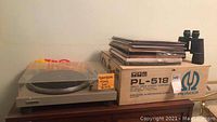 Wide view showing Pioneer PL-518 box, Dual turntable base, record stack, binoculars