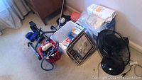 Floor image showing boxed items, grooming equipment, cords, and pieces of exercise equipment on carpeted floor.