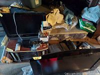 Shows 26-inch Samsung TV and multiple electronics stacked beside it including converters, film, batteries, and the Teac player.