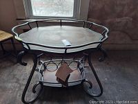 Full view of the Ashley Accents metal tea cart showing curved legs and lower shelf with bottle holders.