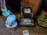 Lot showing the truck clock with chrome finish, the rooster ceramic figurine, the white chicken figurine with visible damage, and the train engine phone.