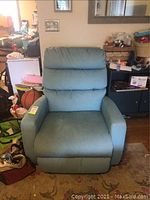 Front view of the sea green electric recliner chair showing upholstery and cushion padding.