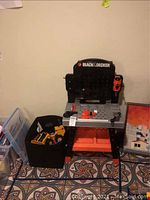 Kids Black & Decker work bench showing branding, structure, and attached toy drill and miter saw.