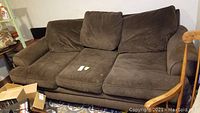 Photo of a large chocolate brown microfiber sofa with three removable seat cushions and three removable back pillows. Visible stains and signs of wear.