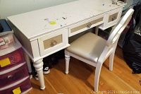 Photo of white Najarian Furniture desk with turned legs and three drawers, showing craft paint stains and wear