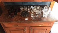 Full view on counter of the crystal vase, cut crystal bowl, various glasses scattered around.