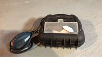 Black and Decker Mouse palm sander and carrying case shown from the top.