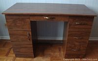 Full view of the small wood veneer desk showing drawers and overall condition