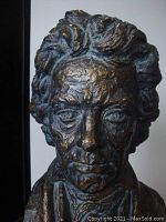 Close-up of the bronze bust showing detailed facial features and textured hair.