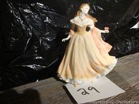 Front-side view of Royal Worcester porcelain figurine depicting a woman in flowing dress holding a butterfly.