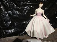 Front view of Royal Doulton figurine of a woman in a pink dress.