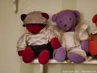 Pair of two teddy bears sitting side by side, Queen Elizabear purple and William Shakesbear red with detailed costumes.