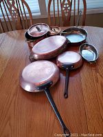 Overview of all cookware pieces arranged on wooden table