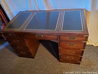 Full front view of desk showing two pedestals, eight drawers and leather inlay top