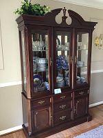 Full front view of the Bassett china hutch showing glass display doors and wooden base.