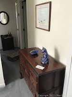 Antique cedar chest seen from hallway, shows side profile, carved drawer fronts and cabriole legs