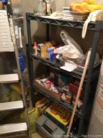 Full view of the metal shelving unit filled with various tools, adhesive products, and other miscellaneous items.