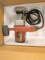 Saw packed in foam-lined box, top-down view showing body and cord coiled