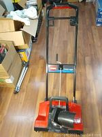 Top perspective of Toro Power Curve 1800 snow blower showing handlebar, control panel, and red housing with snow chute.