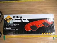 Box top view showing brand name Western Safety, product name Rolling Knee Pads, and key features like ABS plastic, cushioned knees, swivel casters, 250 lbs max weight.