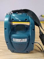 Front view of the Graco HVLP Spraystation HV1900 showing the unit with shoulder strap and spray paint splatter marks.