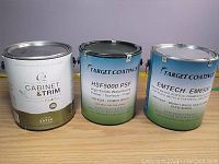 Three cans side by side: C2 Cabinet & Trim paint, HSF5000 PSF primer, EMTECH EM6500 lacquer finish.