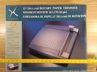 Box front showing 12 inch rotary paper trimmer with image and product highlights.